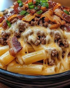 a bowl filled with pasta covered in cheese and meat