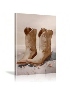 a pair of cowboy boots sitting on top of a white floor next to pink flowers