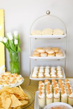 an assortment of snacks and desserts displayed on plates in front of a white wall