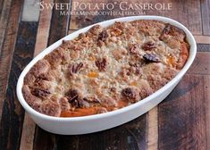 a casserole dish filled with sweet potato casserole on a wooden table