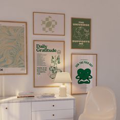 a white dresser sitting next to a wall with posters on it and a lamp in front of it