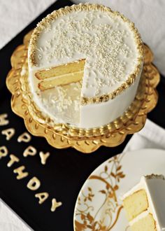 a white cake sitting on top of a black and gold plate