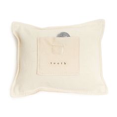 a white pillow with the word tooth printed on it's front and back side