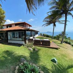 the house is overlooking the ocean and palm trees