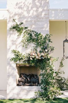 an outdoor fireplace with flowers and greenery on it