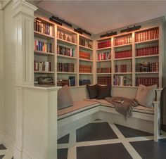 a room with bookshelves and a bench in the corner, all lined up