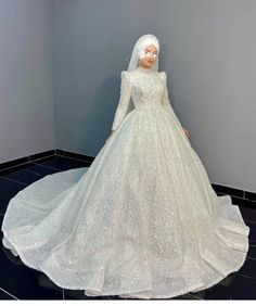 a mannequin dressed in a white wedding dress with long sleeves and a veil