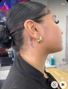 a woman with tattoos on her neck and ear