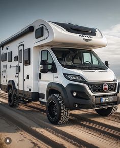 a white camper parked on top of a dirt road