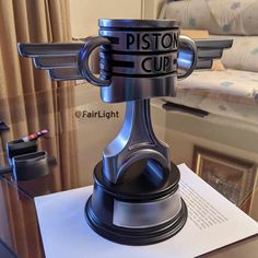 a close up of a metal object on top of a table in a room with curtains