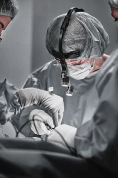 two doctors performing surgery on a patient in an operating room royalty images and stock photos