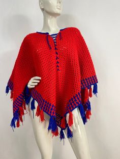 "Crochet knit poncho, knit poncho, red and blue knit, beautiful hand knit poncho  Measurements:  Lying flat width corner to corner 59\"/length from middle to bottom corner 26\"/length of sides 40\" Mannequin measurements:  5'8\", bust 34\", waist 25\", hip 33\" Please note that vintage clothing sizes can vary greatly.  The Measurements provided  are approximate and are taken lying flat.  I suggest taking a similar garment from your wardrobe and measure it while lying flat.  This way you can comp One Size Acrylic Poncho Shawl, Red One-size Poncho Cape, Red One Size Cape Poncho, Red One-size Cape Poncho, Red One-size Cape Shawl, Traditional Red One-size Poncho, Bohemian Red Cape For Festivals, Red Bohemian Shawl Poncho, Red Bohemian Poncho Cape