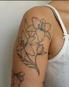 a woman with a tattoo on her arm has flowers in the middle of her arm