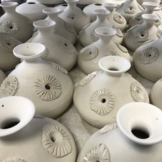 many white vases are lined up on the table