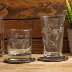 three glasses sitting on top of a wooden table next to a cactus in a pot