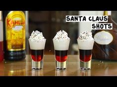 three shot glasses filled with liquid and sprinkles on top of a table