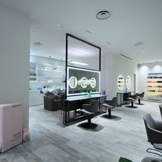 an empty salon with chairs and mirrors in the middle of it, all lit up