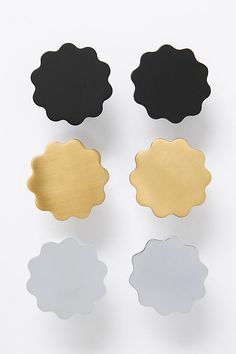 four different shapes of black, gold and silver buttons