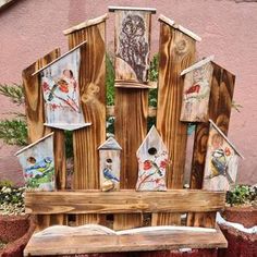 a bench made out of wooden boards with birds on them and birdhouses painted on the back