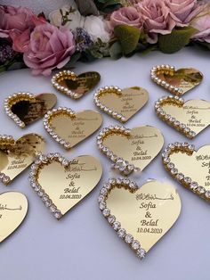 wedding favors are arranged in the shape of hearts with names and date written on them