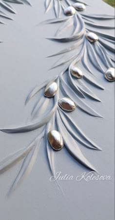 an artisticly designed table with silver leaves on it