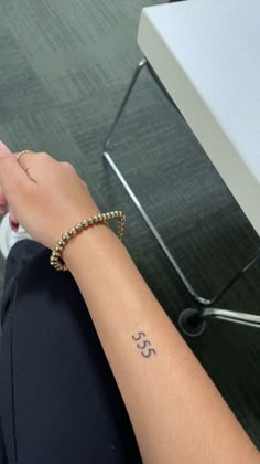 a woman's arm with a small tattoo on it and the number 35 written in cursive writing