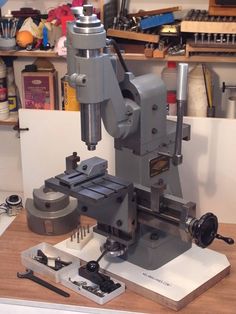 a machine that is sitting on top of a wooden table next to some other tools