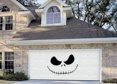 a house with a face painted on the garage door and windows in front of it