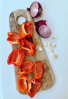 sliced red peppers and onions on a cutting board