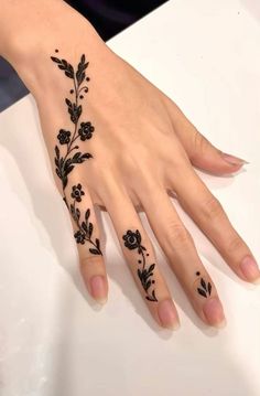 a woman's hand with black flowers on it