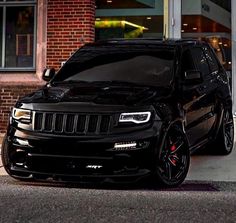 a black jeep is parked in front of a building