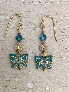 Butterfly Earrings featuring a Czech glass aqua w/brushed gold 15 x 12 MM butterfly accented with a rhinestone ball bead and a 6MM indicolite a/b Swarovski crystal bicone bead.  Gold filled ear wires.  Earrings measure 1 1/2 inches.  Handmade GIFT BOXED Butterfly Dangle Earrings, Butterfly Handmade, Earrings Butterfly, Earrings Diy, Glass Butterfly, Vintage Style Jewellery, Handcrafted Artisan Jewelry, Butterfly Jewelry