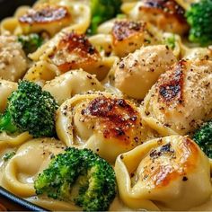 a pan filled with pasta and broccoli covered in cheese sauce on top of a wooden table