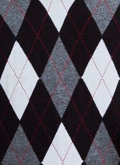 a black and white checkered sweater with red stitching on the bottom, showing an argyle pattern