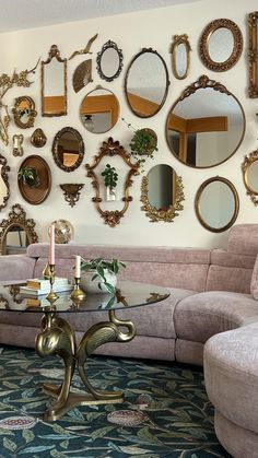 a living room filled with furniture and mirrors on the wall