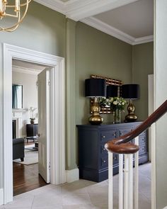 an elegant entry way with green walls and white trim