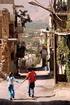 two children are walking down the street holding hands