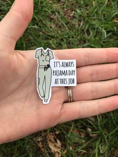 a person's hand holding a pin with a sticker on it that says, it's always pamma day at this job