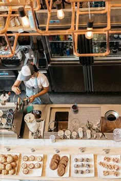 an overhead view of a person preparing food in a kitchen with many lights hanging from the ceiling