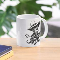 a coffee mug with an octopus wearing a hat sitting on top of a wooden table