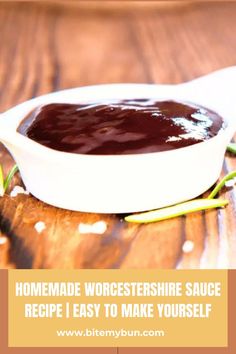 a white bowl filled with sauce sitting on top of a wooden table