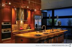 a modern kitchen with wooden cabinets and counter tops, along with an island in the middle