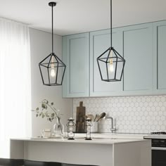 three lights hanging from the ceiling in a kitchen