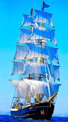 a large blue and white sail boat in the ocean