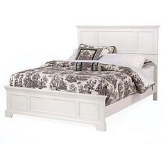 a white bed with black and white comforter on it's headboard, in front of a white background