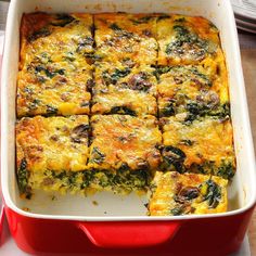 a red casserole dish filled with cheese and spinach