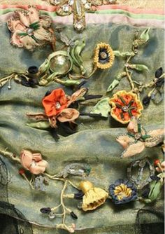 a close up of a cloth with flowers and other things on it, including brooches