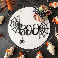 a halloween wreath with the word boo spelled out in black letters and decorations around it