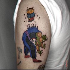 a man with a tattoo on his arm has an image of a cartoon character in the air