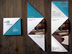 three brochures on a wooden table with wood grain flooring and wallpaper